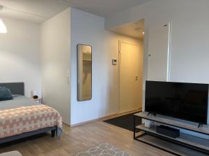 HyryläTyylikäs 35m2 yksiö Hyrylän keskustassa的一间卧室设有平面电视和一张床。