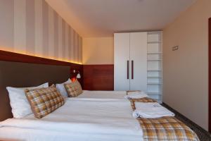 班斯科Ruskovets Thermal SPA & Ski Resort的一间卧室配有两张床和白色橱柜