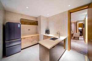 Shiyan十堰天海温德姆酒店的厨房配有水槽和冰箱
