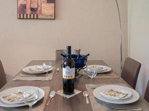 西维耶兹Apartment Rosablanche C61 by Interhome的一张桌子,上面放着一瓶葡萄酒和盘子