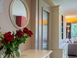 西维耶兹Apartment Rosablanche C51 by Interhome的一张带镜子的桌子上红玫瑰花瓶