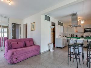 布科·莱斯白老城Holiday Home Les Baïnes - VIB220 by Interhome的一间带紫色沙发的客厅和一间厨房
