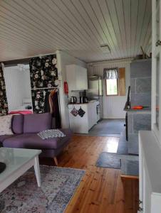 MannervaaraMökki Mannervaarassa, Joensuussa的一间带紫色沙发的客厅和一间厨房