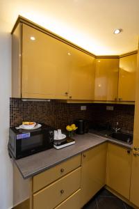 布达佩斯朋友旅馆公寓的厨房配有黄色橱柜和微波炉