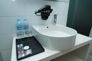 邦加槟港Grand Safran Hotel Pangkalpinang的浴室水槽和柜台上的瓶装水