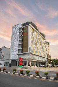 邦加槟港Grand Safran Hotel Pangkalpinang的道路一侧酒店 ⁇ 染