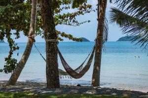象岛Sea Escape Koh Chang的海滩上两棵棕榈树之间的吊床