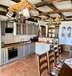 维齐纳达Villa Filoreto的厨房配有灰色橱柜和桌椅