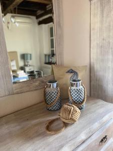 维齐纳达Villa Filoreto的两瓶花瓶坐在镜子前的木桌旁