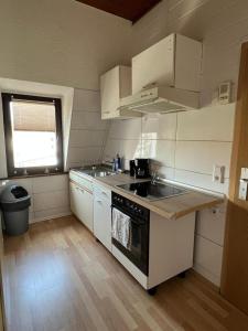 多特蒙德DO One Bedroom Flat的厨房配有白色橱柜和炉灶烤箱。