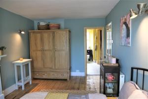 兰贝德Dolafon的一间卧室设有蓝色的墙壁和木制橱柜。