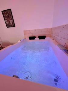南希A0 Grand Appartement, Jaccuzi, et extérieur Thermal Artem à 200m的客房内的大浴缸里装满了蓝色的水