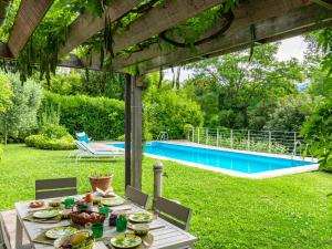 格里安泰卡德纳比亚Villa Villa Ulivo by Interhome的一张桌子,上面有食物,放在带游泳池的院子