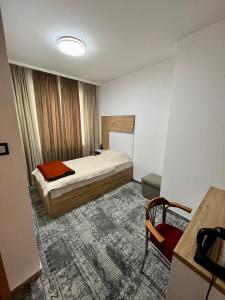 萨拉热窝Hotel Brkic的一间卧室配有一张床、一张桌子和一张书桌