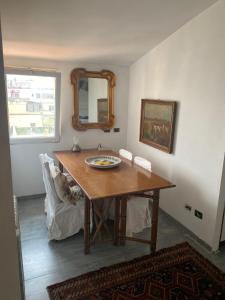 罗马Apartment in Roma with Terrace的一间带桌子和镜子的用餐室