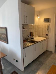 罗马Apartment in Roma with Terrace的厨房配有白色橱柜和水槽