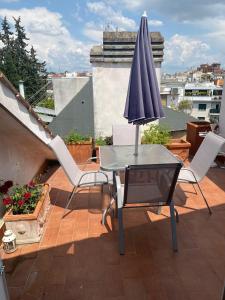 罗马Apartment in Roma with Terrace的屋顶上配有遮阳伞的桌椅