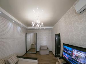 敖德萨Апартаменты на Марсельской, Кадорр, 4я Жемчужина的客厅配有吊灯和电视。