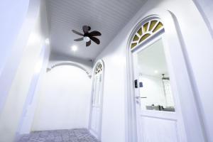 奈汉海滩4号酒店的白色走廊,设有门和吊扇