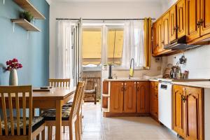 GastoúniNice central family apartment的一间带木制橱柜和桌子的厨房以及一间用餐室