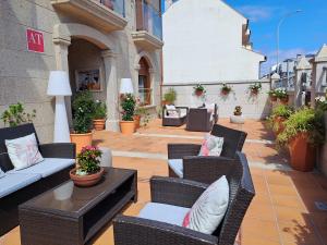 维拉加尔西亚·德·阿劳萨Apartamentos Playa Compostela的庭院设有藤椅和桌子,种有植物