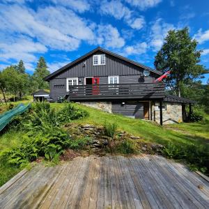 KvamBjørnebu- Ski in-ski out的山丘上带木甲板的房子