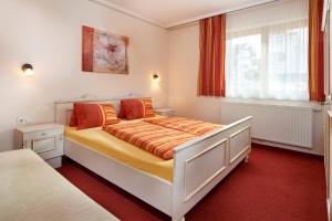 弗拉绍加尼塔伦霍夫公寓式酒店的一间卧室配有带橙色床单的床和窗户。