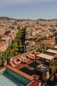 巴塞罗那Nobu Hotel Barcelona的一个带椅子的屋顶游泳池,享有城市美景