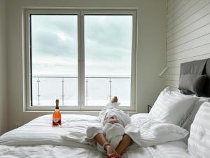 赫塔HavsVidden Resort的躺在床上的人,带一瓶啤酒