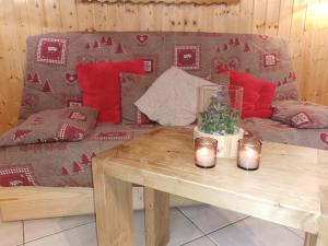 雷加霍斯达哈施Demi-Chalet l'Ancolie -- Prox pistes的客厅配有沙发和带蜡烛的桌子