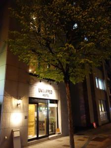 札幌未开发旅馆的夜晚在建筑物前的树