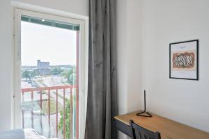 图尔库Norden Homes 2-Bedroom Apartment的一间卧室设有窗户,享有阳台的景色
