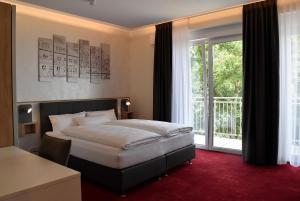爱尔福特Hotel am Waldkasino的一间卧室设有一张床和一个大窗户