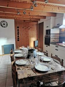 雷加霍斯达哈施Demi-Chalet l'Ancolie -- Prox pistes的厨房里一张桌子,上面有盘子和玻璃杯
