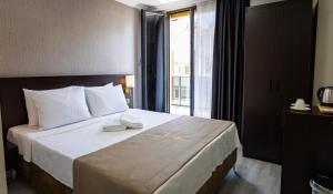 伊斯坦布尔Mays Royal Hotel的酒店客房设有一张床和一个大窗户