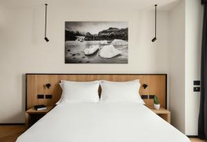 努马纳View Place & Spa的卧室配有白色的床和墙上的绘画作品