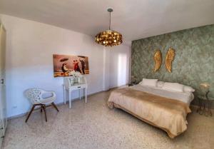 塞维利亚El Patio de San Bernardo的一间卧室配有一张床、一张桌子和一个吊灯。