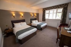 马尔堡Castle and Ball by Greene King Inns的酒店客房设有两张床和窗户。