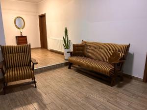 大波兰地区奥斯特鲁夫Hostel Sadowianka的一间等待室,配有两把椅子和一张沙发