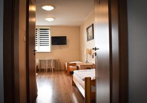 大波兰地区奥斯特鲁夫Hostel Sadowianka的一间卧室配有一张床、一张桌子和一张桌子