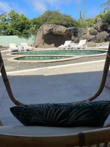 努尔德2 Bedrooms - Rock Palma Apartments的吊床享有泳池美景,配有椅子