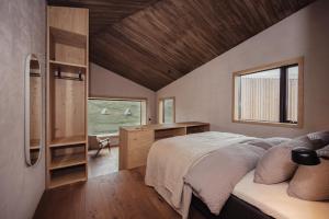 KerlingarfjollHighland Base Kerlingarfjöll的一间卧室配有一张床、一张书桌和一个窗户。