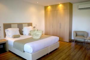 维琪奥港Hotel Restaurant Mariosa的一间卧室配有一张带橱柜和椅子的床