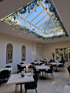 WoodboroughWoodborough Hall的餐厅设有桌椅和玻璃天花板