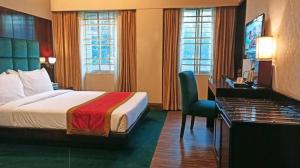 达卡West Park Inn的配有一张床和一张书桌的酒店客房