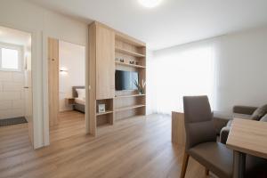 萨尔路易斯Smart & Stay Aparthotel Saarlouis Lisdorf - Self-Check-In - Free Parking的客厅配有沙发和电视。