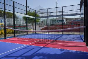 Sant Feliu de BuixalleuCàmping Vila Village的停车场内带网的网球场