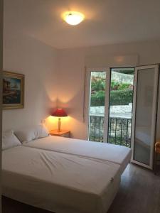 佩德雷尔Nice 4 Person apartment residence La Sella Golf Resort Marriott Denia的一间卧室配有一张带灯和窗户的床