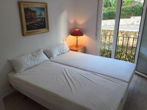 佩德雷尔Nice 4 Person apartment residence La Sella Golf Resort Marriott Denia的窗户客房内的一张白色床