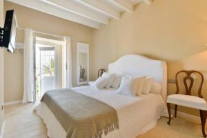 伊维萨镇Dalt Vila House的卧室配有白色的床和椅子